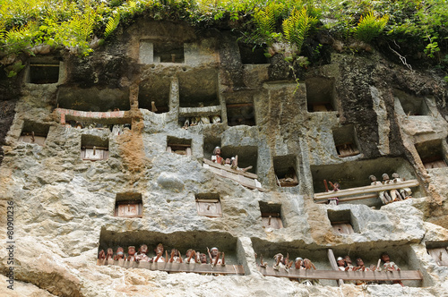 Ancient forged tombs in rock guarded by puppets