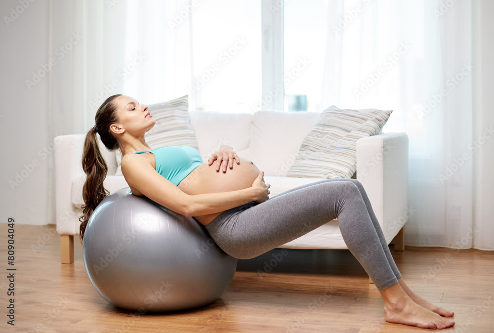 happy pregnant woman exercising on fitball at home happy pregnant woman exercising on fitball at home