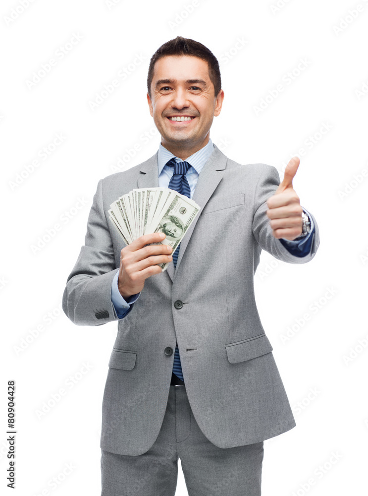 smiling businessman with money showing thumbs up smiling businessman with money showing thumbs up