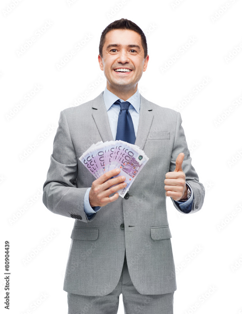 smiling businessman with money showing thumbs up smiling businessman with money showing thumbs up