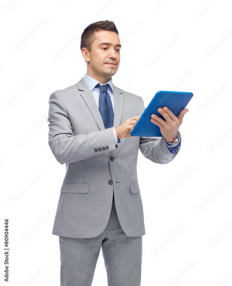 happy businessman in suit holding tablet pc