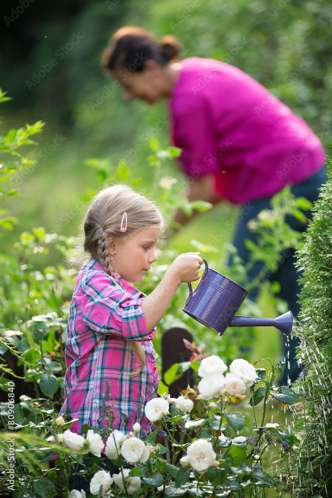 Mädchen und Oma bei der Gartenarbeit, Blumen gießen Mädchen und Oma bei der Gartenarbeit, Blumen gießen