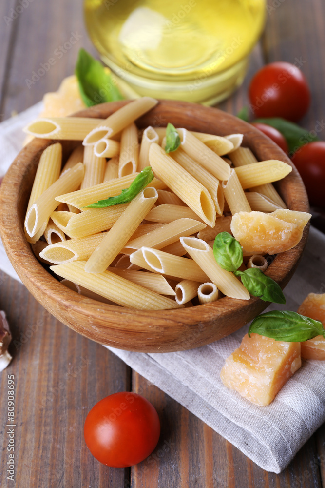 Raw pasta in bowl with cheese and vegetables on table close up Raw pasta in bowl with cheese and vegetables on table close up