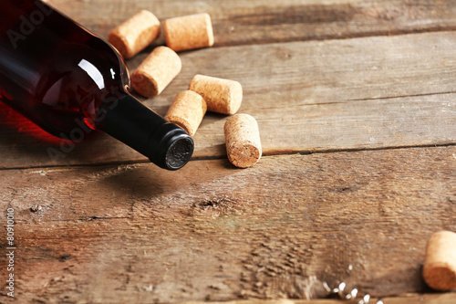 Glass bottle of wine with corks and corkscrew