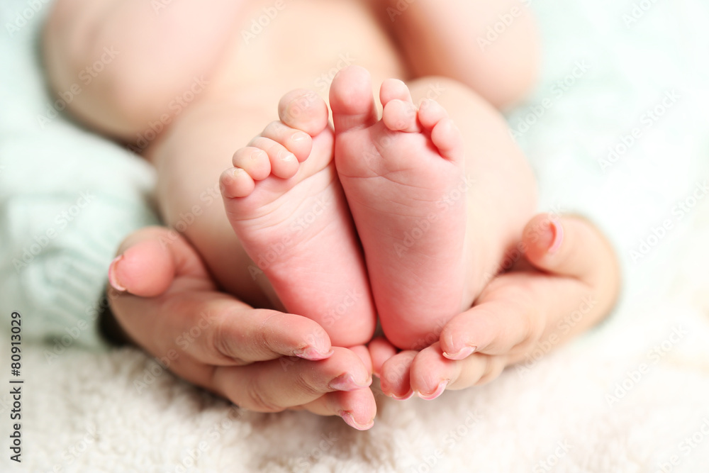Newborn baby feet on female hands, close-up Newborn baby feet on female hands, close-up