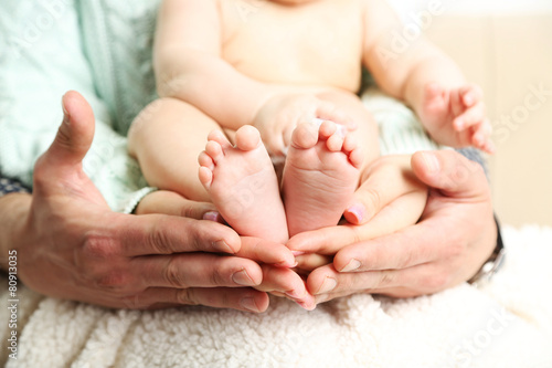 Newborn baby on father and mother hands, close-up
