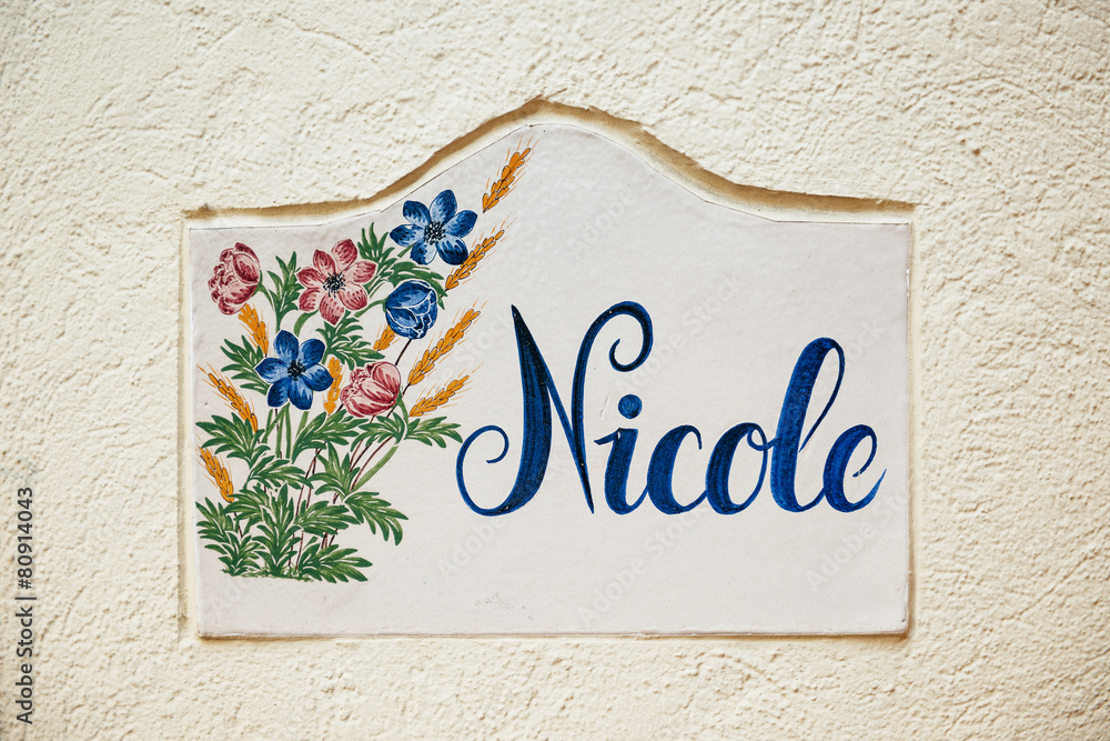 Nicole - old tile on city street wall with flower and beautiful Nicole - old tile on city street wall with flower and beautiful