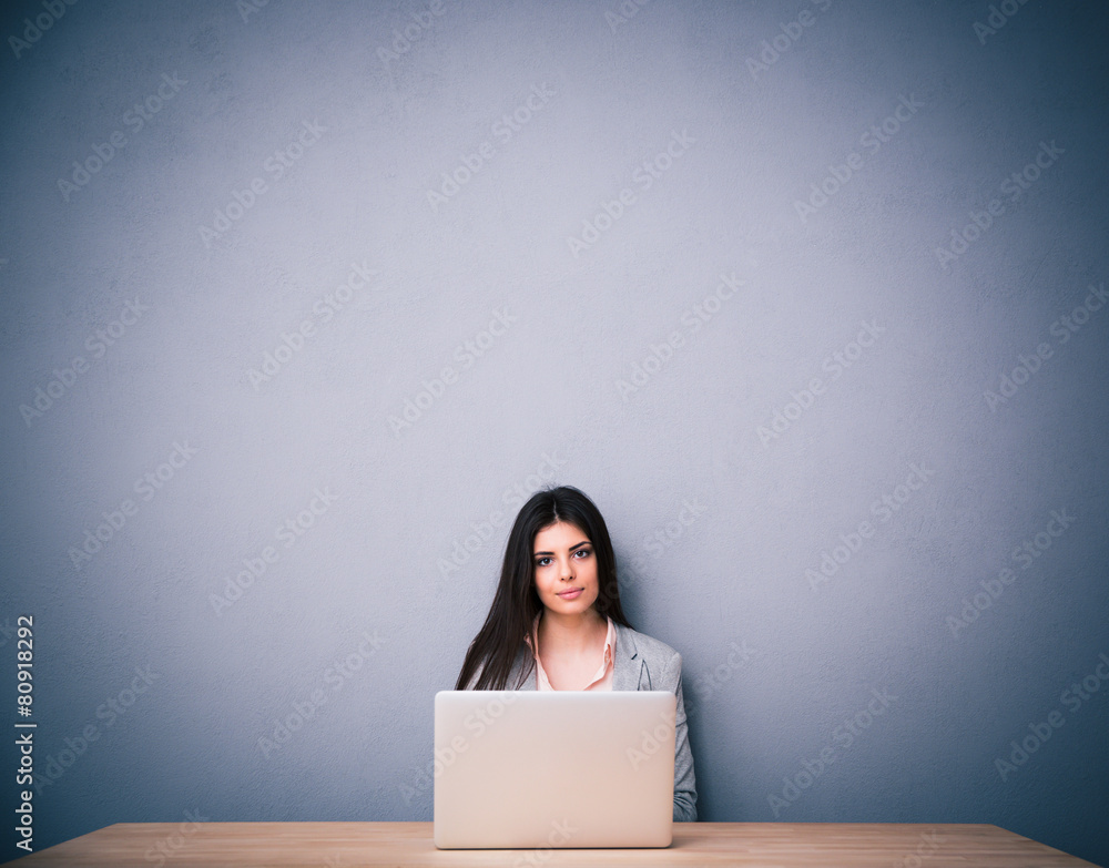 Beautiful woman sitting on the table with laptop Beautiful woman sitting on the table with laptop