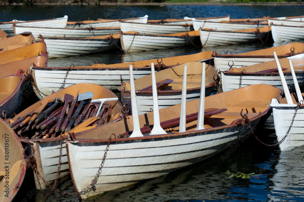 boats with oars on blue water in park at springtime boats with oars on blue water in park at springtime