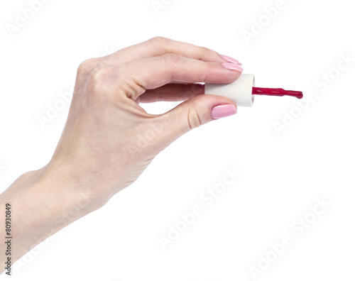 female hands with red manicure and nail polish bottle with brush