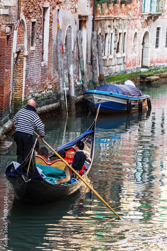 Venetian gondolier punting gondola in Venice Italy © GoodPics