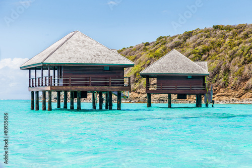 Two Buildings on Stilts Above Tropical Water