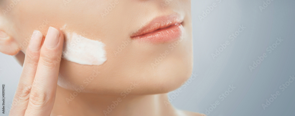 Woman applying facial cream Woman applying facial cream