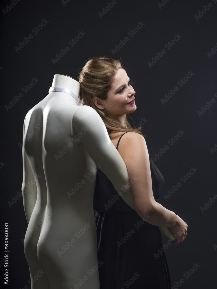 Woman in evening gown dancing with a manequin Woman in evening gown dancing with a manequin