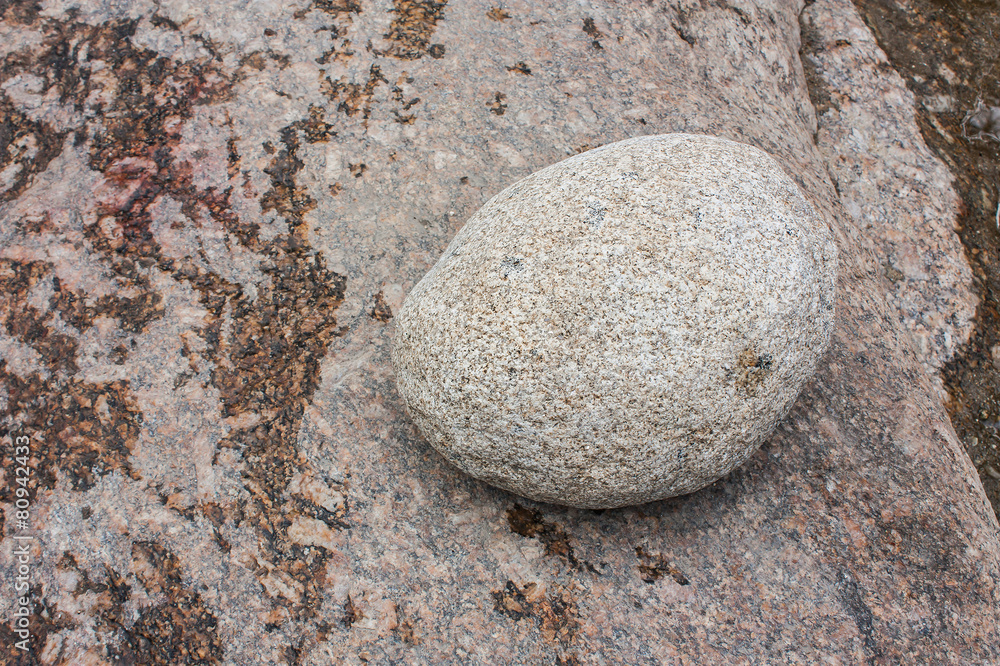 Oval white stone on the wet rock Oval white stone on the wet rock