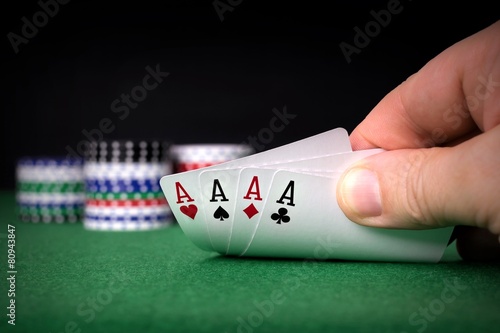A poker hand of four aces with chips and copy space background photo