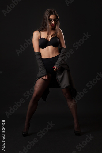 Sexy brunette woman with retro black lingerie. Black background.