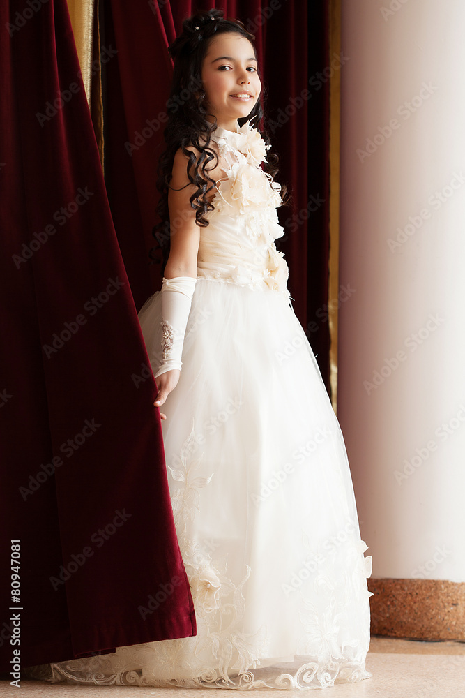 Smiling girl in elegant dress coming out of scenes
