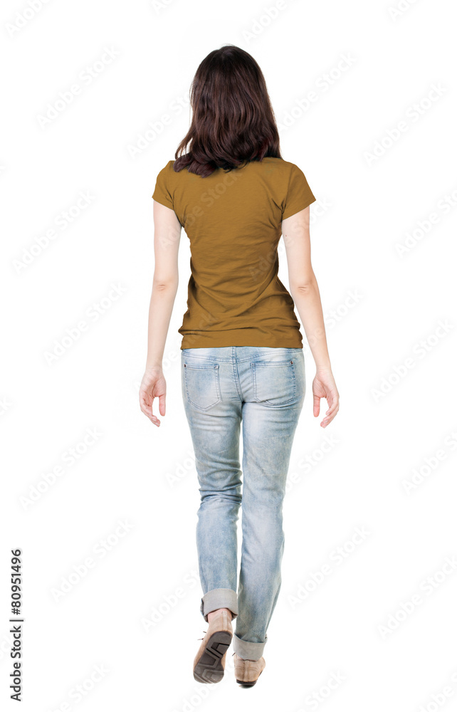 Obraz premium back view of walking woman in jeans .