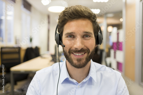 Foto Cheerful Businessman in the office on video conference, headset,