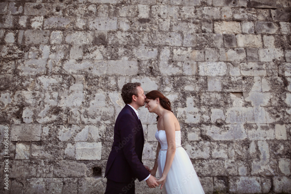 Bride and groom kissing near brick wall Bride and groom kissing near brick wall