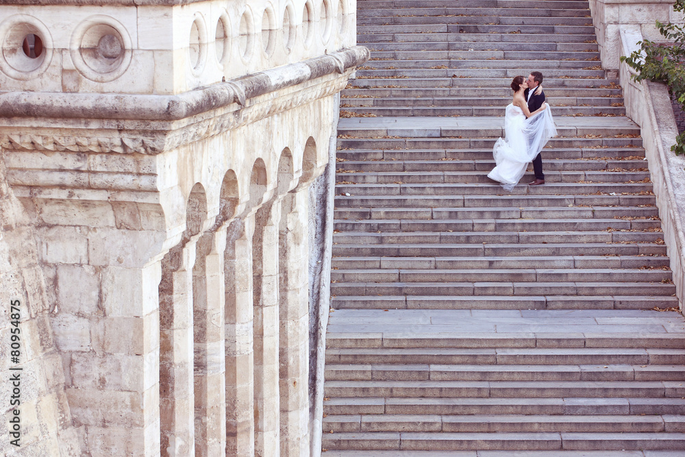 Bride and groom kissing on stairs