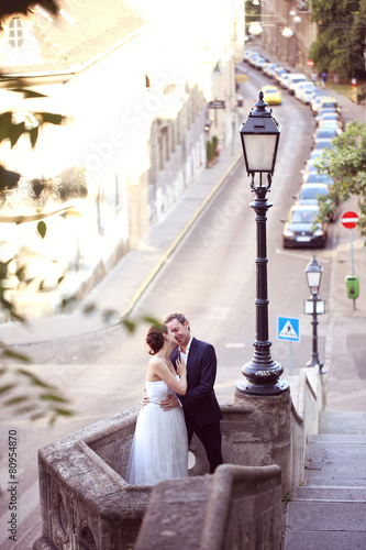 Bride and groom on a small balcony in the city