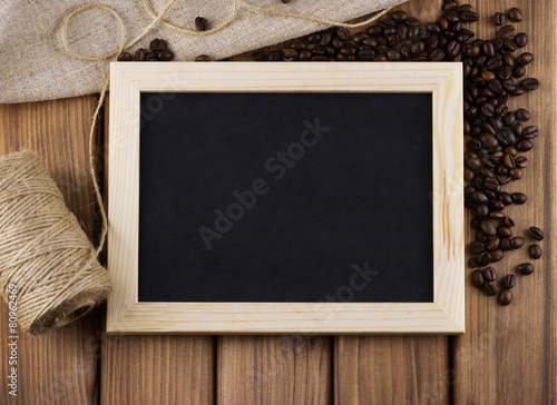 Blank blackboard with roasted coffee beans, twine and sackcloth