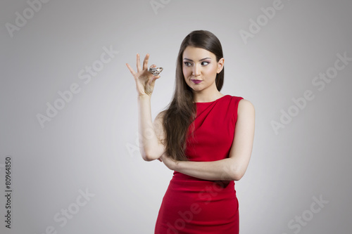 Young woman in elegant red dress holding giant diamond