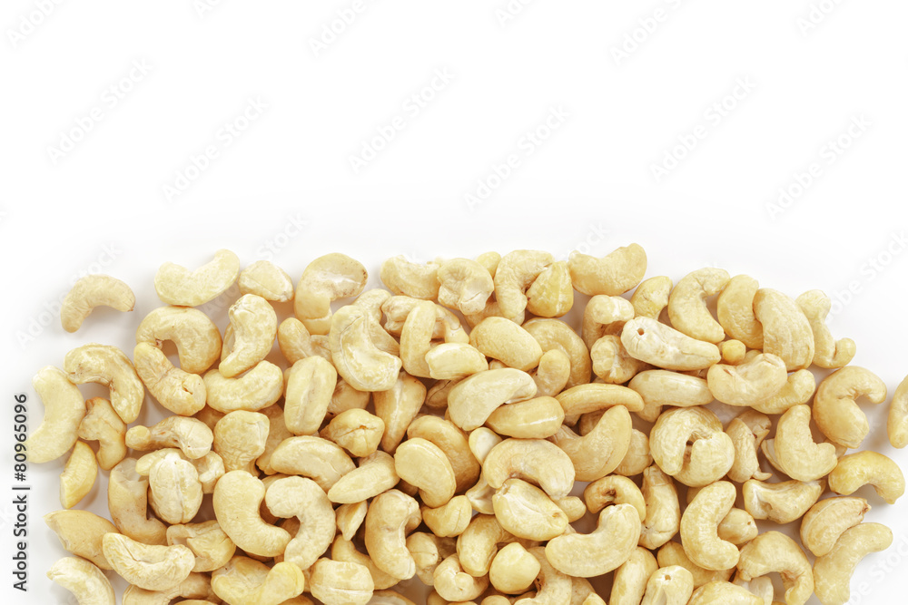 border of dry cashew nuts on white background