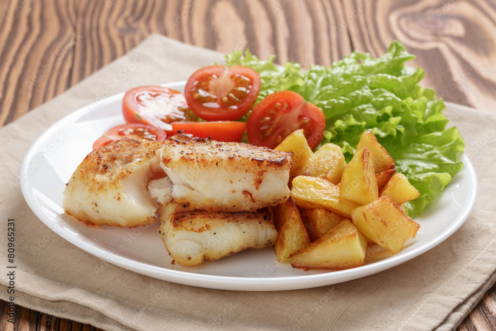 fried fish fillet with vegetables on wood table fried fish fillet with vegetables on wood table