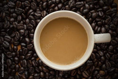 Hot latte coffee cup on coffee beans background.