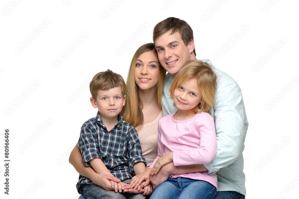 Young family of four posing and looking at camera