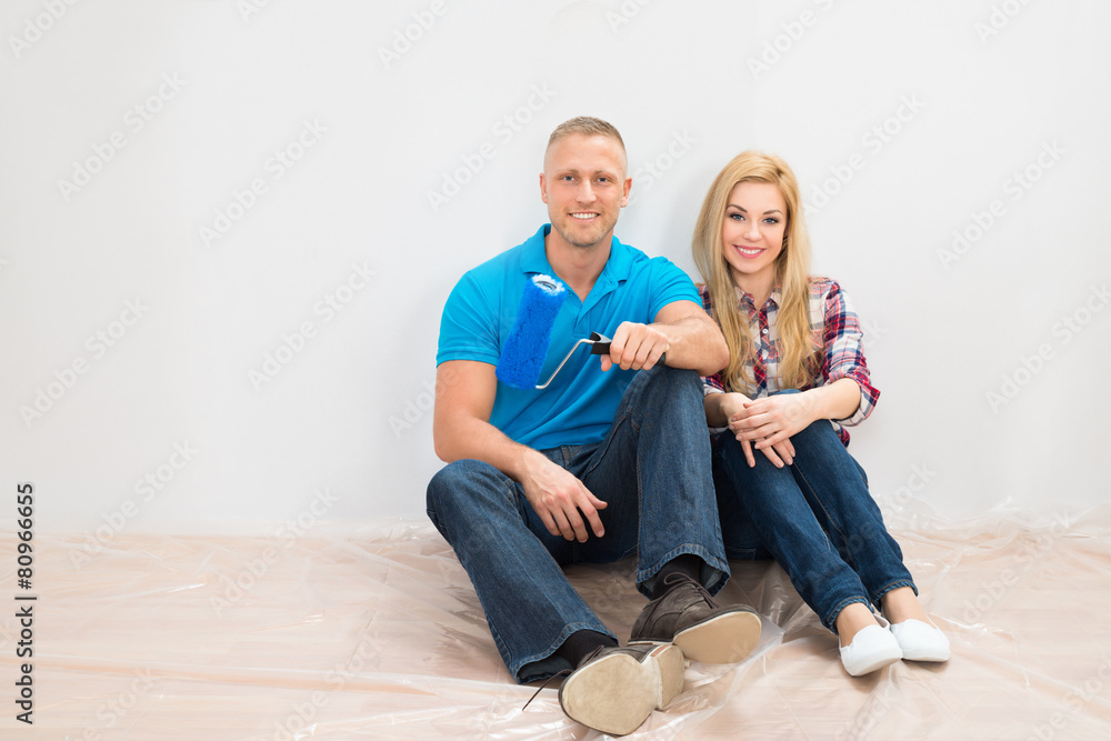 Happy Couple In Front Of Partially Painted Wall