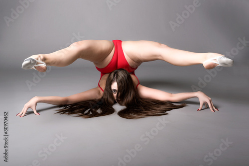 Young female contortionist, on dark background