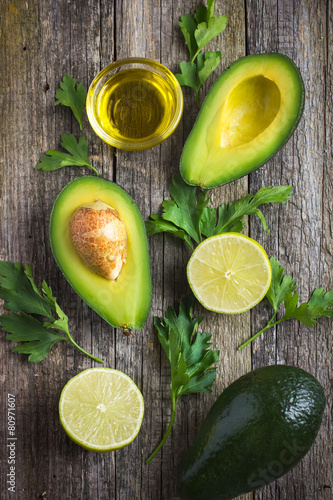 Foto food background with fresh organic avocado, lime, parsley and ol