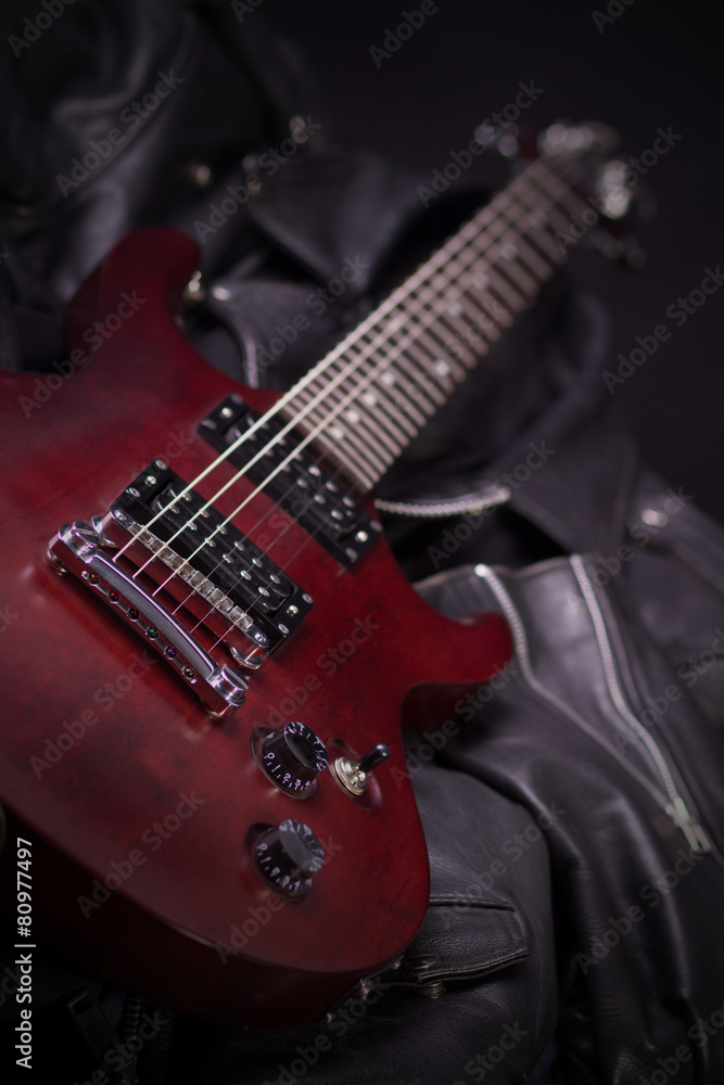 Fototapeta premium Electric guitar lying on black leather jackets
