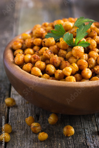 Roasted  spicy chickpeas on rustic background