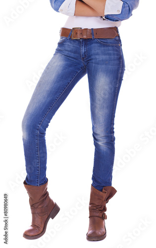 Front view of a standing woman model wearing denim with brown bo