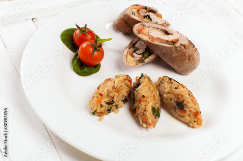 meat rolls with rice tomato and spinach on the plate