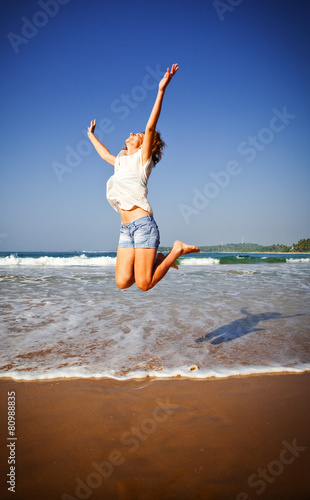 Woman Jumping In The Air On Tropical Beach