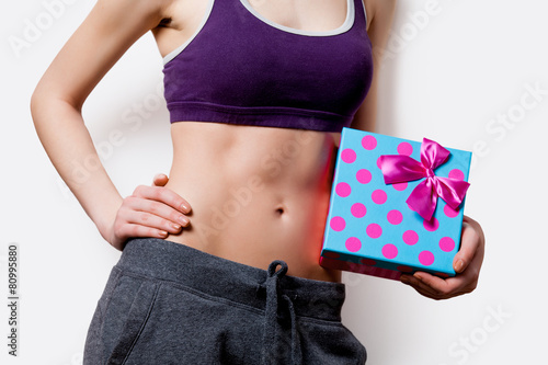 Φωτογραφία Woman showing her abs with gift box