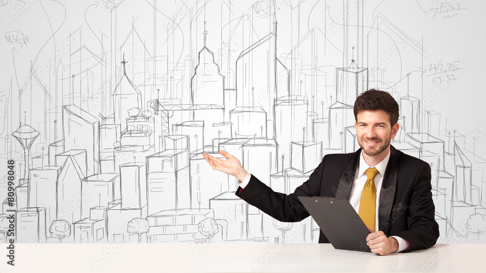 Businessman sitting at the white table with hand drawn buildings Businessman sitting at the white table with hand drawn buildings