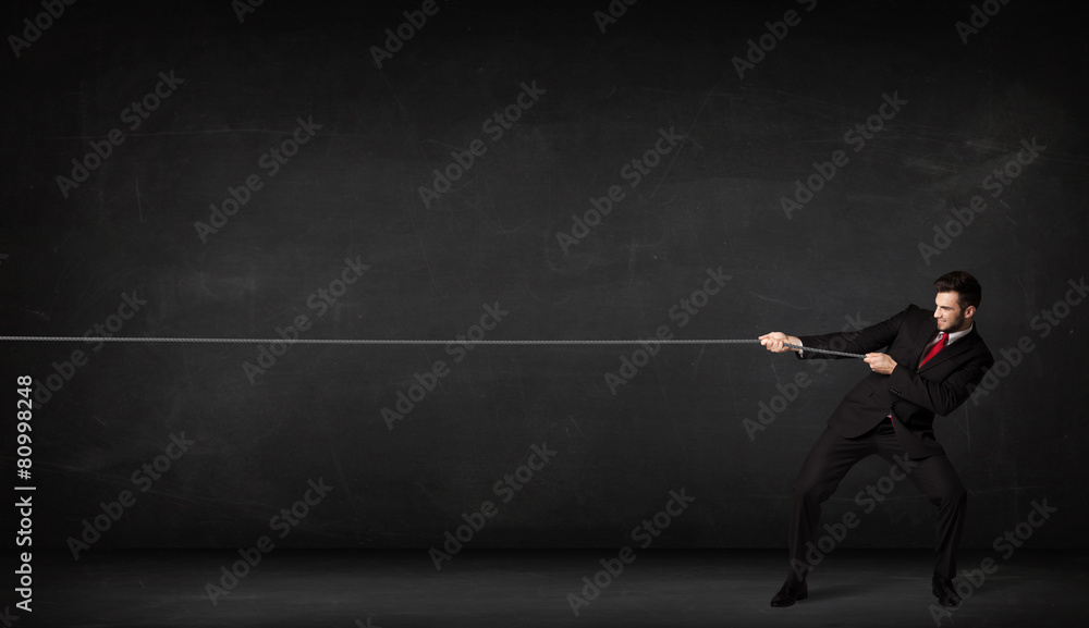 Obraz premium Businessman pulling rope on grey background