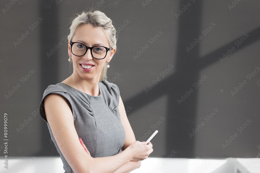 Smiling young teacher standing in front of blackboard