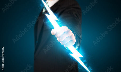 Business man holding glowing lightning bolt in his hands