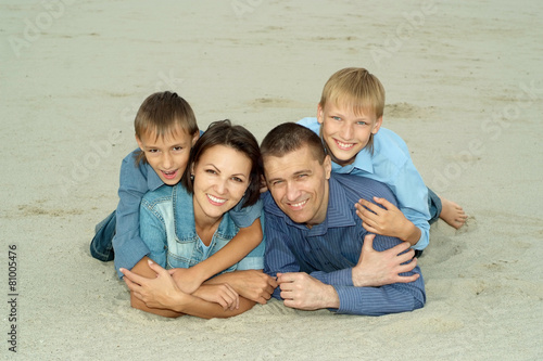 family lying on the sand 