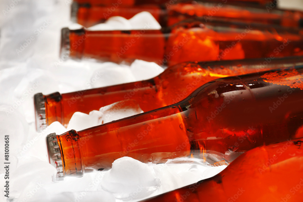 Glass bottles of beer with ice cubes, closeup Glass bottles of beer with ice cubes, closeup