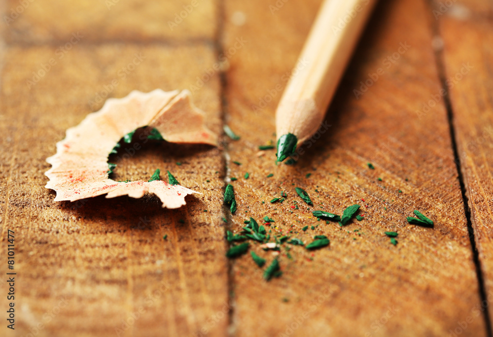 Wooden color pencil with sharpening shavings on wooden table Wooden color pencil with sharpening shavings on wooden table