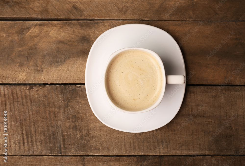 Cup of coffee on wooden table, top view